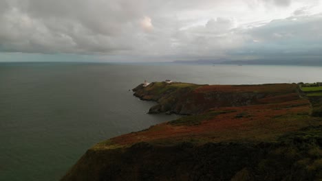 Luftaufnahme-Einer-Klippe-Mit-Einem-Leuchtturm-In-Irland-An-Einem-Bewölkten-Tag