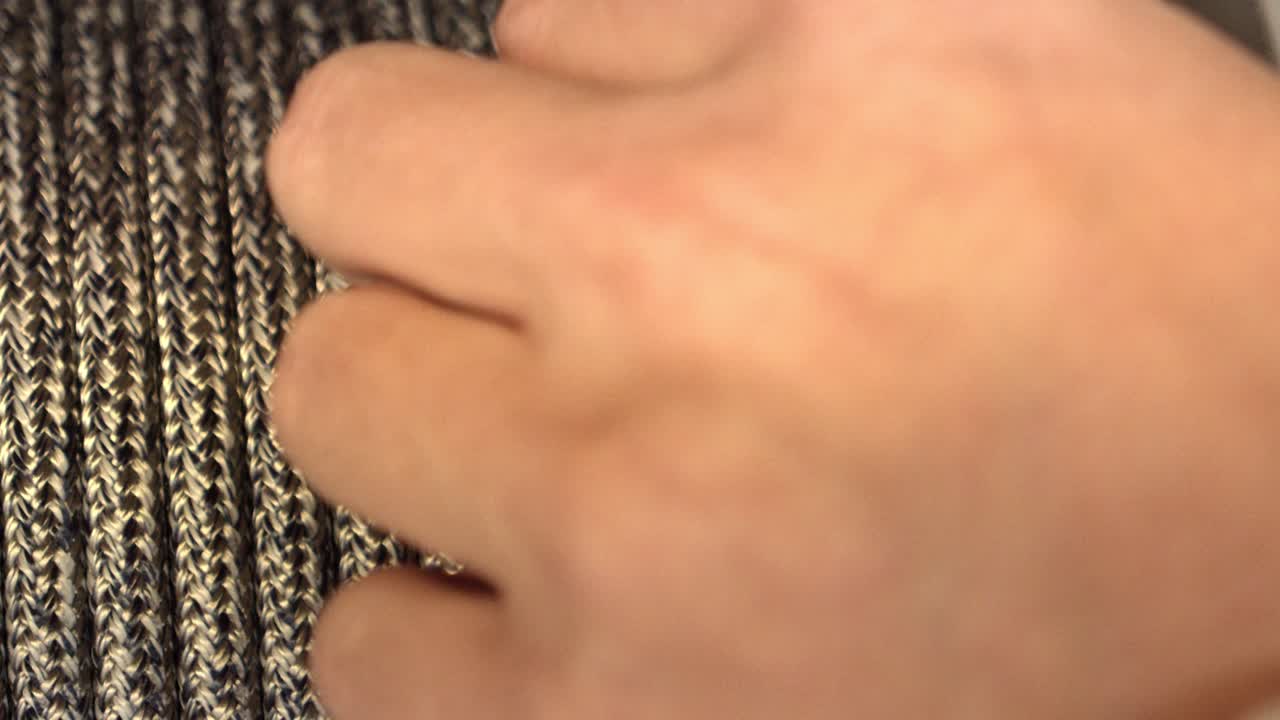 새 팔찌를 준비하기 위해 은색 끈을 사용하는 장인의 손, 매크로 클로즈업 보기