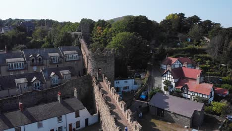 people walking along the historic stone wall of conwy town in wales, aerial view