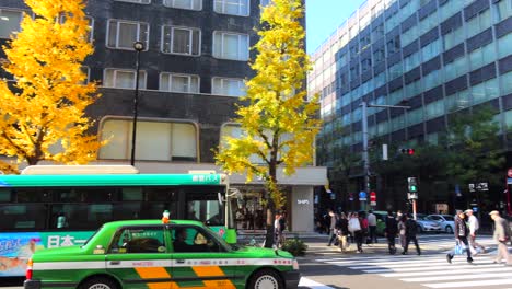 city center of tokyo with buses and cars and people walking around, 4k panning right