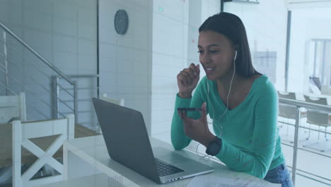 animación del procesamiento de datos del mercado de valores sobre una mujer afroamericana haciendo una llamada de video en una computadora portátil.