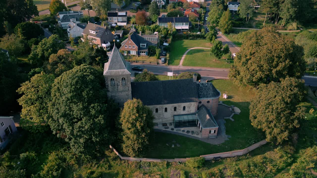 나무와 마을 집으로 둘러싸인 oosterbeek의 역사적인 oude kerk, 여름 동안 포착 된 개혁 된 교회.