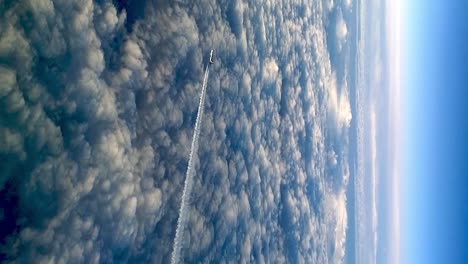 avión volador por encima de las nubes dejando un rastro de aire de vapor de condensación en el cielo azul