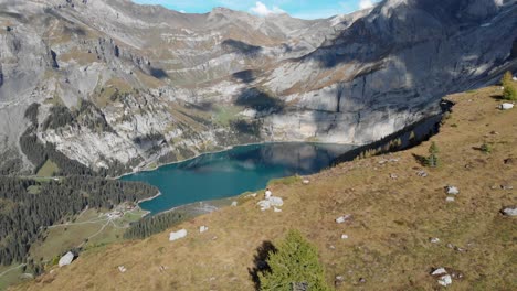 flyover a mountain cliff revealing the world famous oeschinensee in switzerland