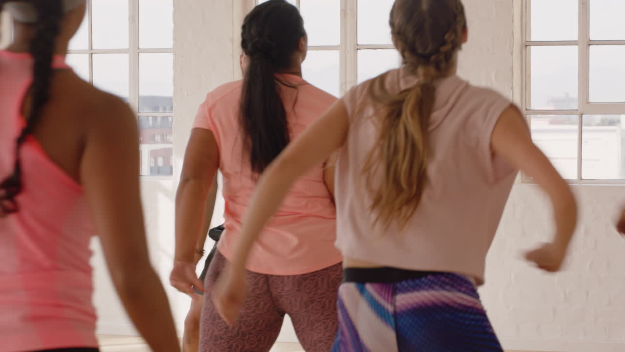 instructor de clase de baile entrenando a un grupo de personas multirraciales bailando practicando movimientos de coreografía divirtiéndose en el gimnasio disfrutando de un estilo de vida activo y saludable