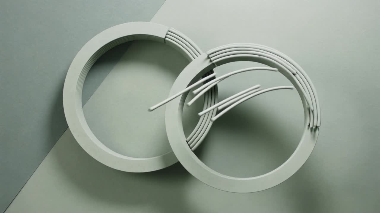 Pale rings on tabletop, gap aligning causing rods uncoiling and sweeping leftward for design