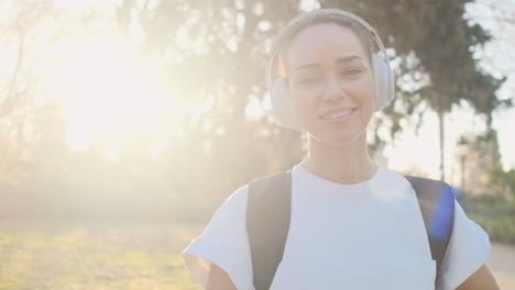 Vista-Cercana-De-Una-Hermosa-Mujer-Con-Auriculares-Y-Mochila.