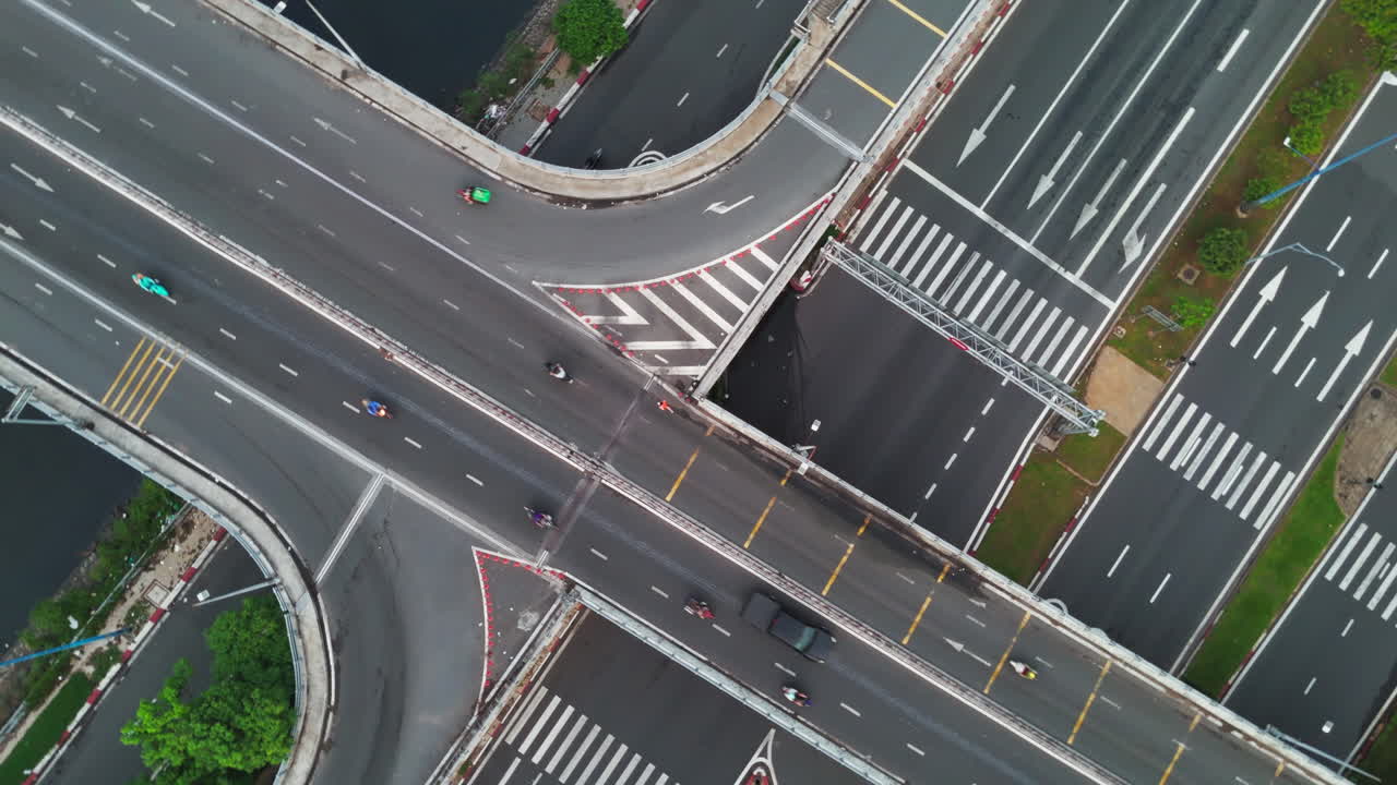 This dynamic stock footage captures the bustling energy of a city intersection from above. Watch as cars weave through the traffic, pedestrians cross the streets.