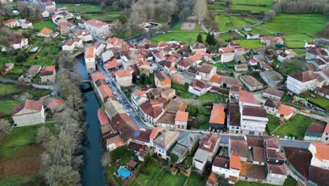 drone orbit around quaint spanish village built up around molgas river in ourense