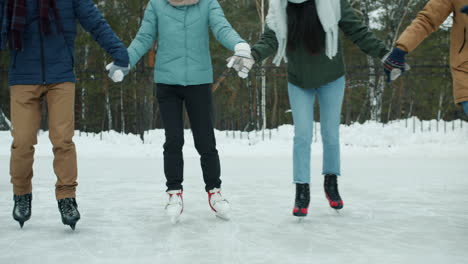 friends ice skating in winter park