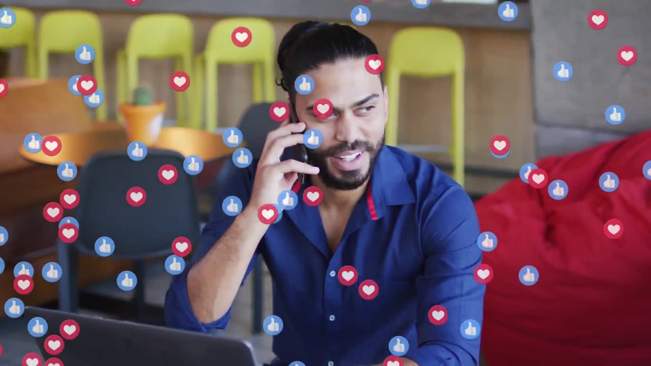 animación de iconos emoji de las redes sociales sobre empresario biracial usando un teléfono inteligente.