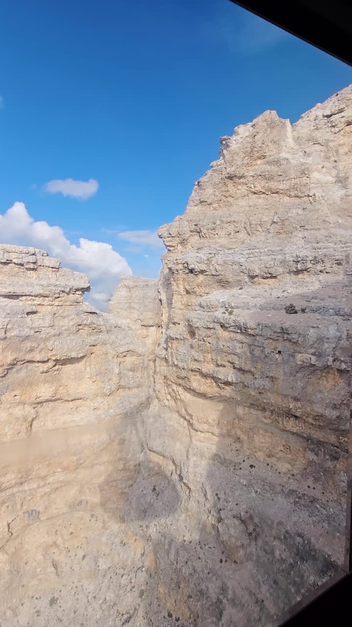 Vertical frame captures shadow of cable car on stone as it climbs in Italy