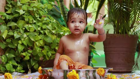 cute toddler baby boy bathing in decorated bathtub at outdoor from unique perspective