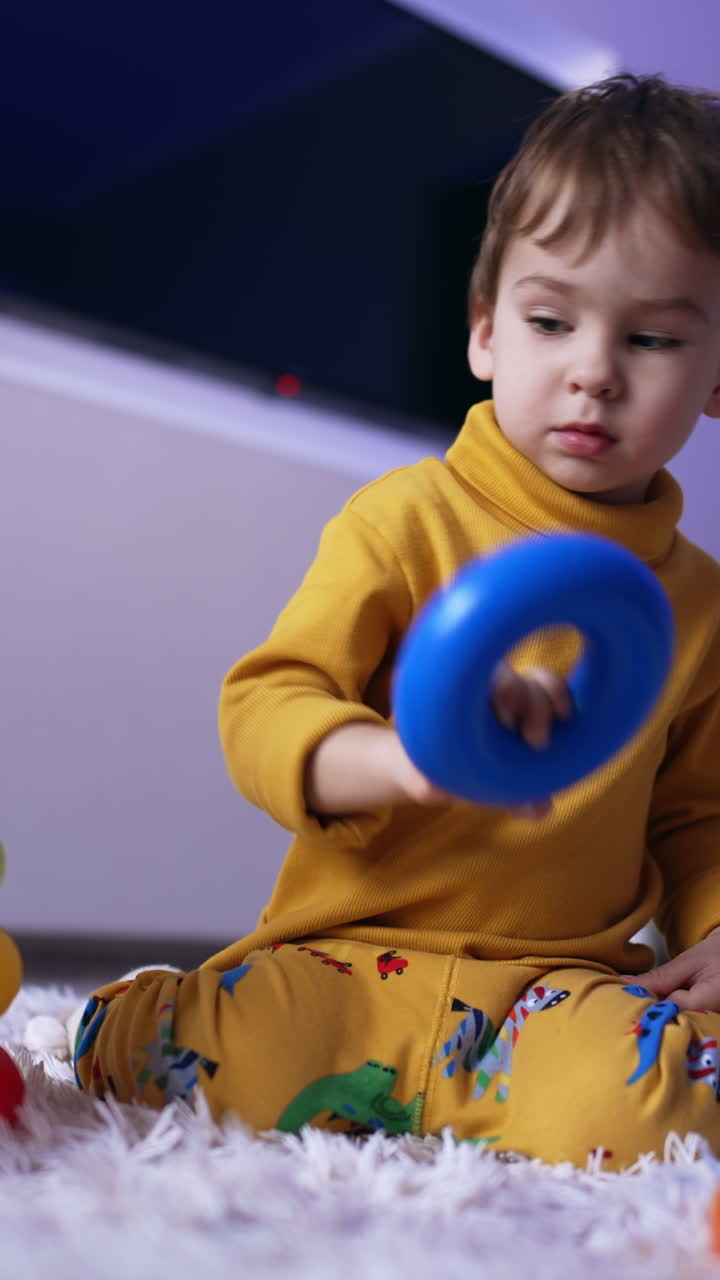 Lovely Caucasian toddler assembling the toy pyramid