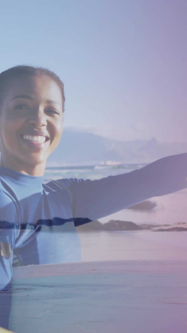 Animation of happy african american couple with surfboards over seascape