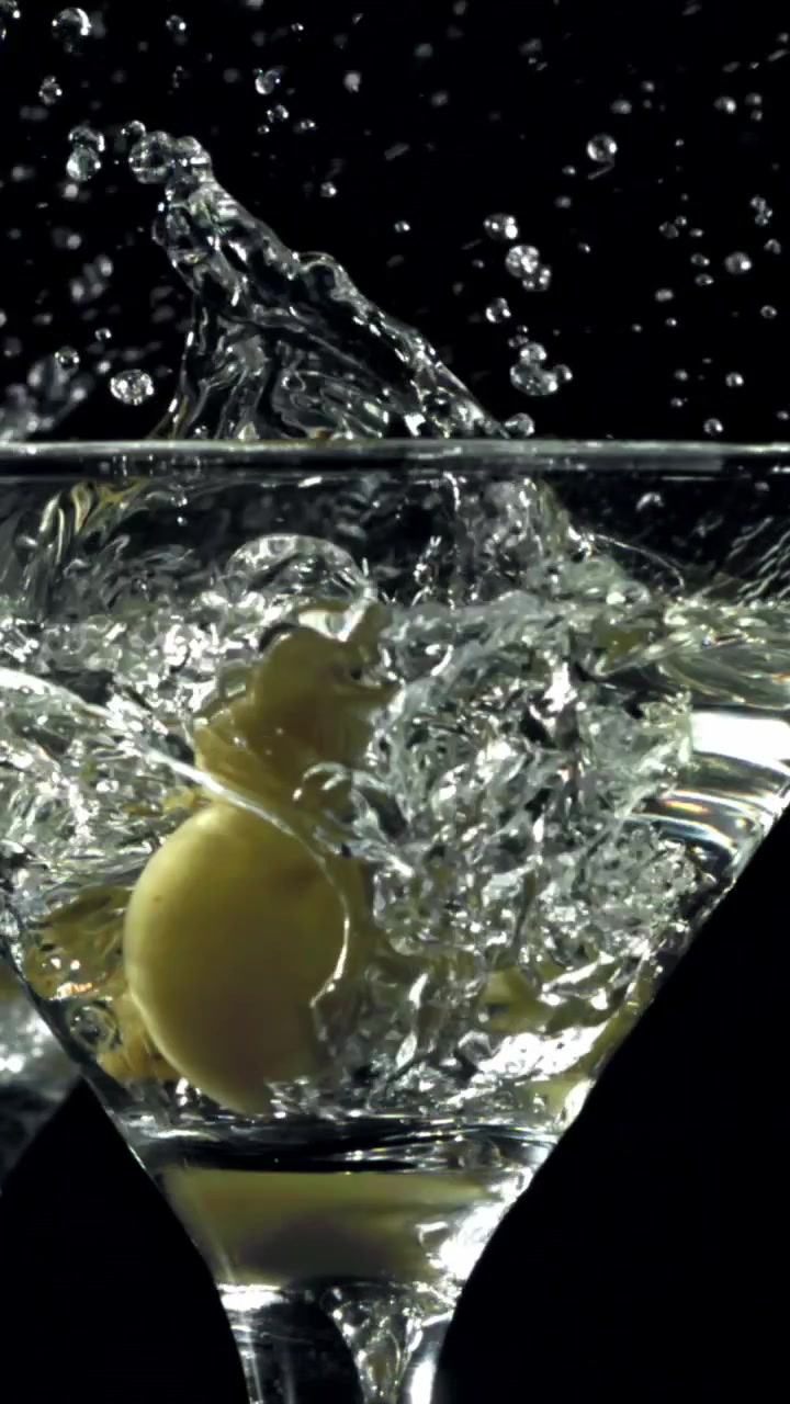 Oliva che cade in un bicchiere da Martini al rallentatore