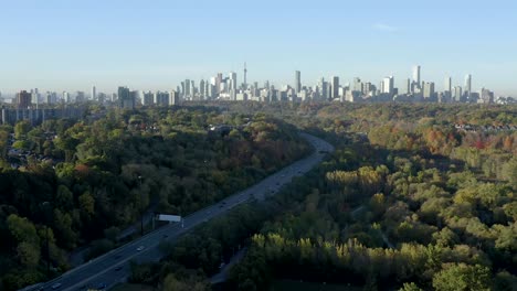 cinematic drone tilts up over the don valley in toronto, canada to reveal the cn tower skyline