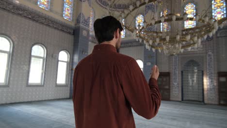 man standing in mosque praying