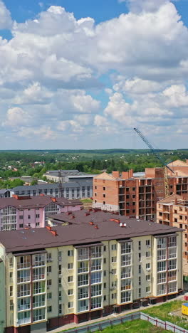 construction of new residential district. modern multi storey apartment buildings in construction site against blue sky. tower crane build high rise buildings. vertical video