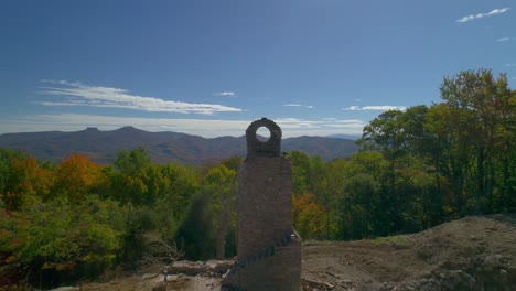 avión no tripulado volando cerca de una chimenea de ladrillo abandonada en las montañas a medida que se acerca la caída