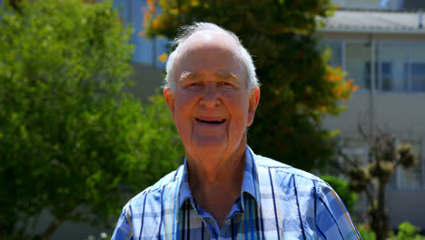 Front-view-of-Active-Caucasian-senior-man-standing-in-the-garden-of-nursing-home-4k