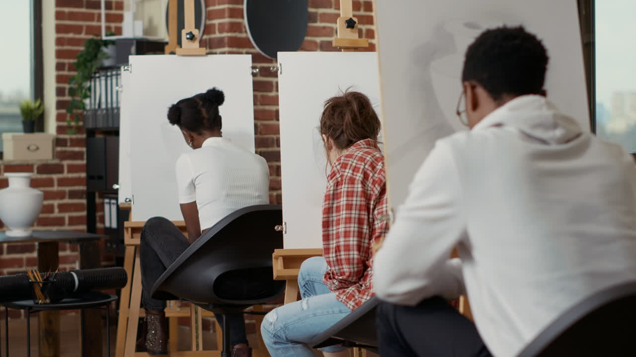 Elder artist helping young student with vase model drawing