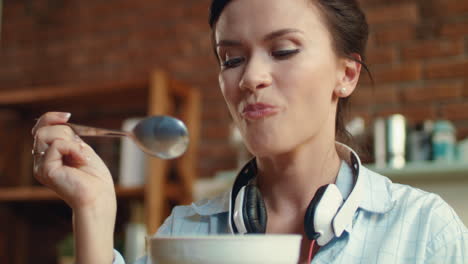 Woman-eating-cornflaces-with-milk-in-kitchen.-Girl-enjoying-cereal-for-breakfast