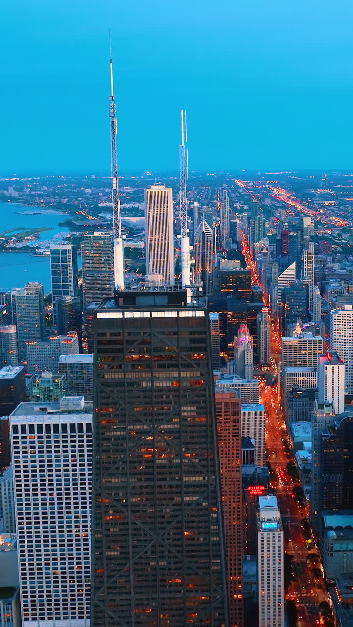 Evening business city landscape. Colored blue dusk skyline. Aerial view of skyscrapers and streets with Chicago lights. Vertical video