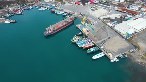 port of shengjin in albania, piers where fishing and commercial ships are anchored with unloading cranes