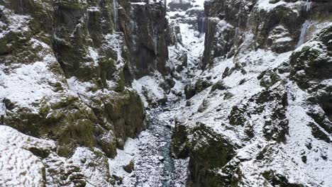 Una-Vista-Aérea-Serpenteando-A-Través-Del-Cañón-Mulagljufur-Conduce-A-La-Cascada-Mulafoss-En-Austurland-Islandia