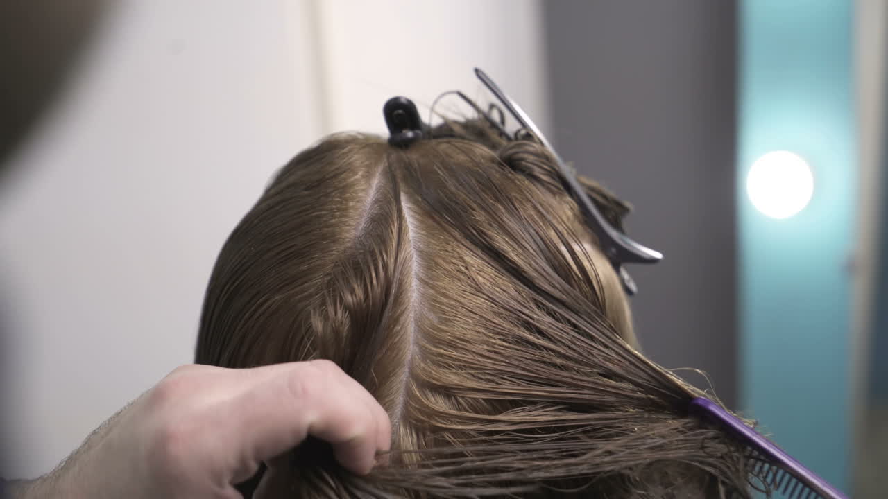 Hairdresser cutting hair of her customer at the hairdressing salon