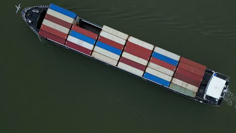 aerial top down view of cargo containers being transported on river