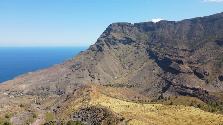 Parco naturale di Tamadaba, Tirma: veduta aerea che attraversa un paesaggio fantastico con alte montagne e Roque Faneque in questo parco naturale sull'isola di Gran Canaria in una giornata di sole