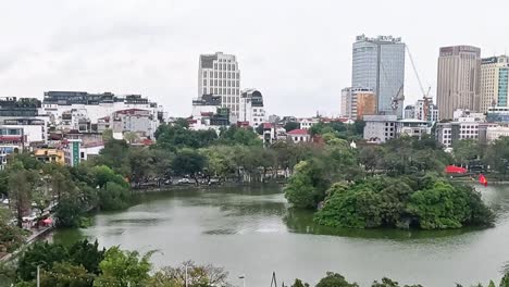 a serene island surrounded by water with a backdrop of urban high-rises and greenery.