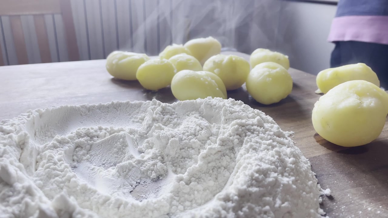Inquadratura statica di vapore che sale da patate calde con farina per la preparazione di pasta artigianale
