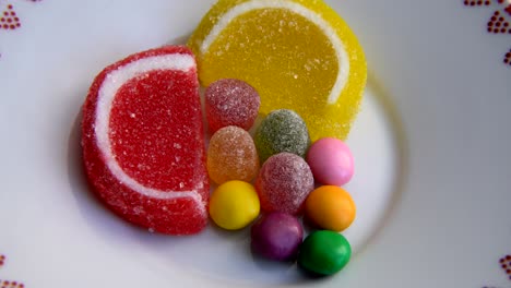 heart shaped multicolored fruity candies are rotating on turntable