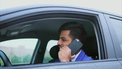 hombre hablando por teléfono mientras conduce