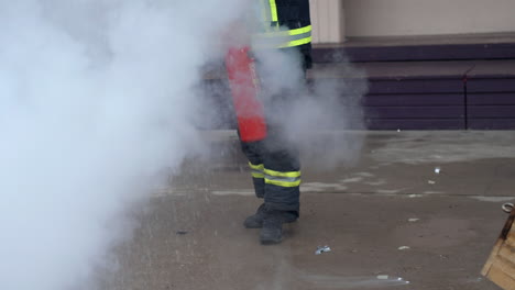 Nicht-Erkennbare-Feuerwehrpraxis-Mit-Feuerlöscher,-Um-Feuer-In-Zeitlupe-Zu-Löschen