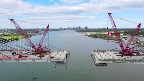 gordie howe international bridge construction with lattice boom crawler cranes, aerial dolly out view