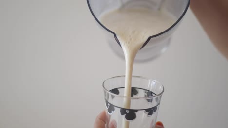 pouring a smoothie into a glass