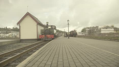 on a cloudy day, a steam engine that inspired thomas the tank engine arrives at the train station