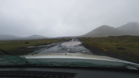 Vista-Desde-Un-Automóvil-Conduciendo-Por-Un-Camino-Embarrado-Con-Baches-En-Islandia.