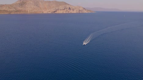 Vídeo-De-Un-Dron-Que-Muestra-Una-Lancha-Rápida-Acercándose-Al-Vibrante-Océano-Azul-Frente-A-Grecia