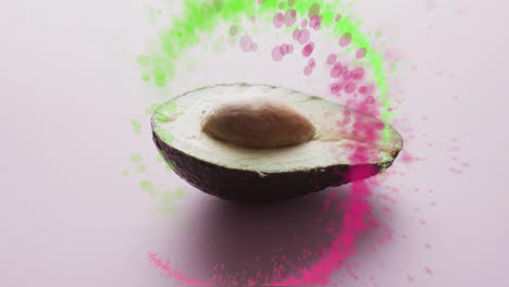 Komposition-Aus-Lichtpunkten-über-Halbierter-Avocado-Auf-Rosa-Hintergrund