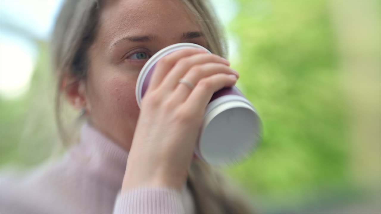 Brunette woman drinking coffee outside