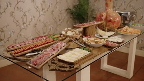 delicious buffet table with sliced meats cheeses bread and seafood at a rustic indoor event