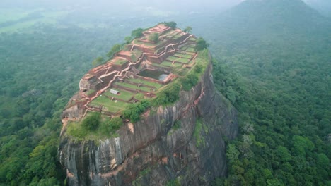 lion's rock in sigiriya , mountain with historical buildings among great vegetation, sunset on a cloudy day