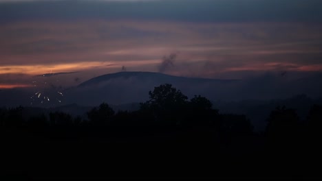 firework bursts in shimmering light up in dusk sky in slow motion