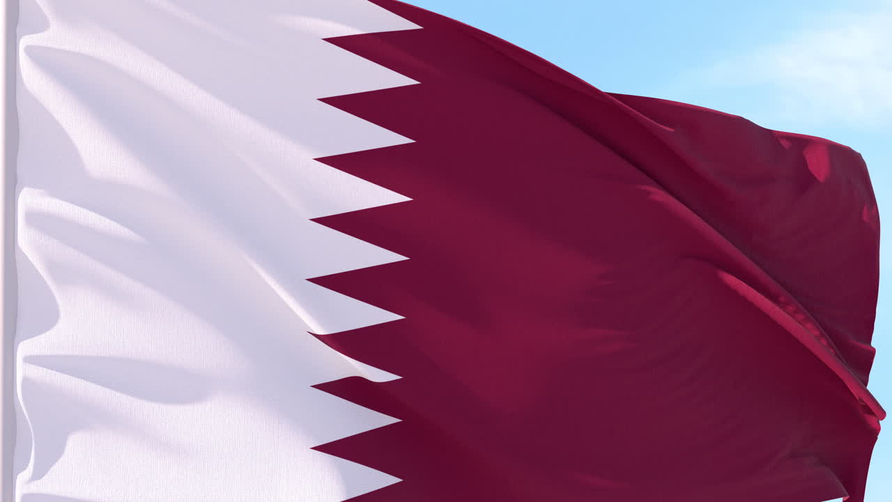 Bandiera del Qatar che sventola al vento contro il cielo blu