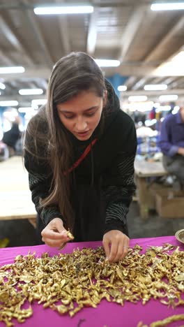 woman shopping for gold figurines at a market